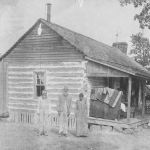 The Torian cabin dates to 1845 and was located in the Dove community. Torian family members occupied the cabin until the 1940s. Pictured are, l-r, Buck Sowell, John Torian and his daughter, Ella Torian. SHS Archives